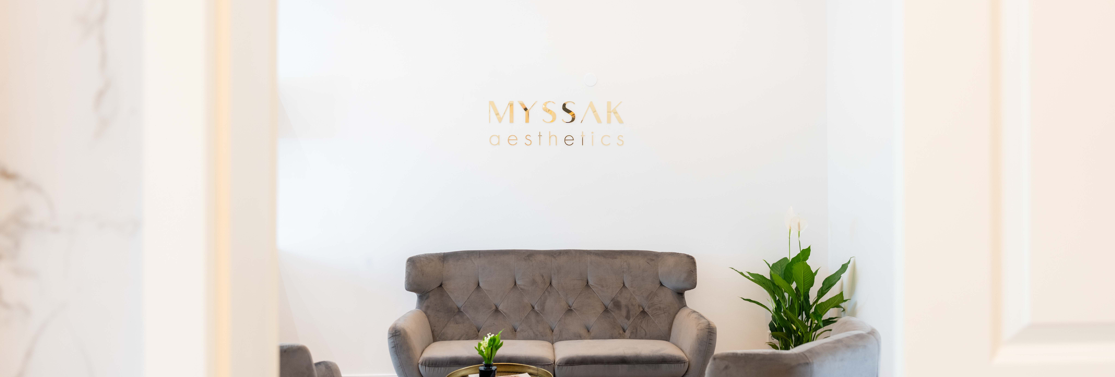Bild von einem Raum in einer Privatpraxis mit einem Sofa und dem Logo von MYSSAK aesthetics